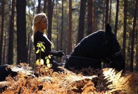 Фото девушки верхом на вороной лошади